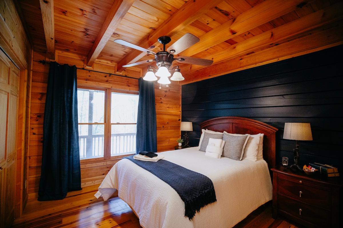 Удобна спална соба на главниот кат со брачен кревет (широк 150-179 см), дрвени ѕидови и таван, меко осветлување и топло, рустикално чувство. Вклучува ноќни шкафчиња, светилки и големи прозорци со поглед кон шума. Совршено за опуштање.