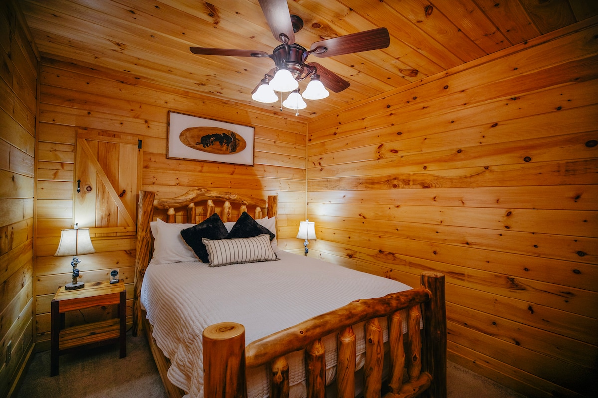 Оваа удобна брачна спална соба има рустикални дрвени ѕидови, рачно изработен кревет од трупци, меко осветлување и шармантен декор на дрвената колиба - совршен за мирен ноќен одмор во топол, привлечен амбиент.