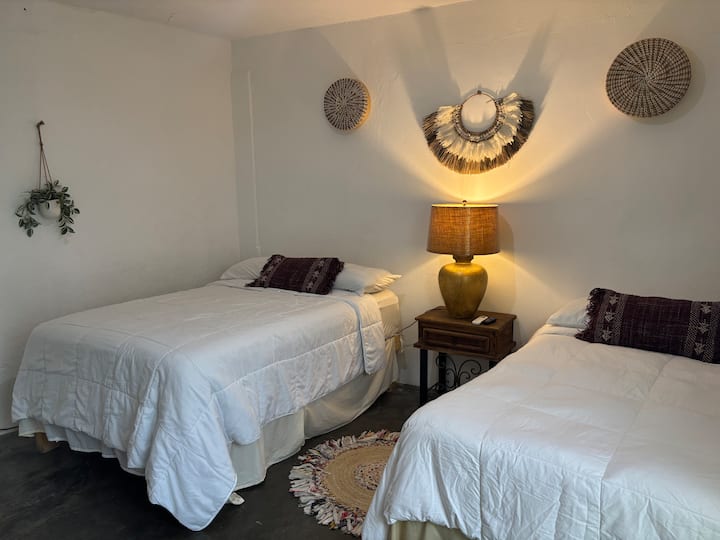 Prekrasna spavaća soba s dva bračna kreveta, savršena za odmor u potpunoj udobnosti. Klima-uređaj, pametni TV, WiFi. Detalji od pruća daju ugođaj topline i udobnosti te stvaraju opuštajuću atmosferu idealnu za vaš boravak.