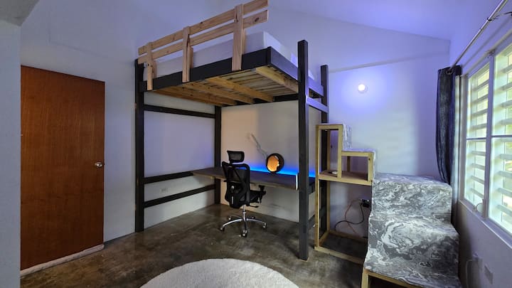 Room on the second level with a queen bed, soft lighting, A/C, and mountain views.