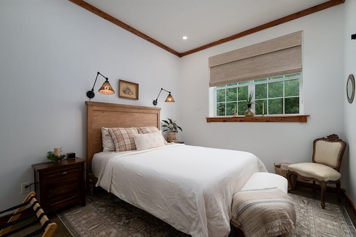 Wake up to peaceful forest views in a thoughtfully designed queen bedroom featuring soft cotton bedding, blackout shades, and everything you need for a restful night’s sleep.