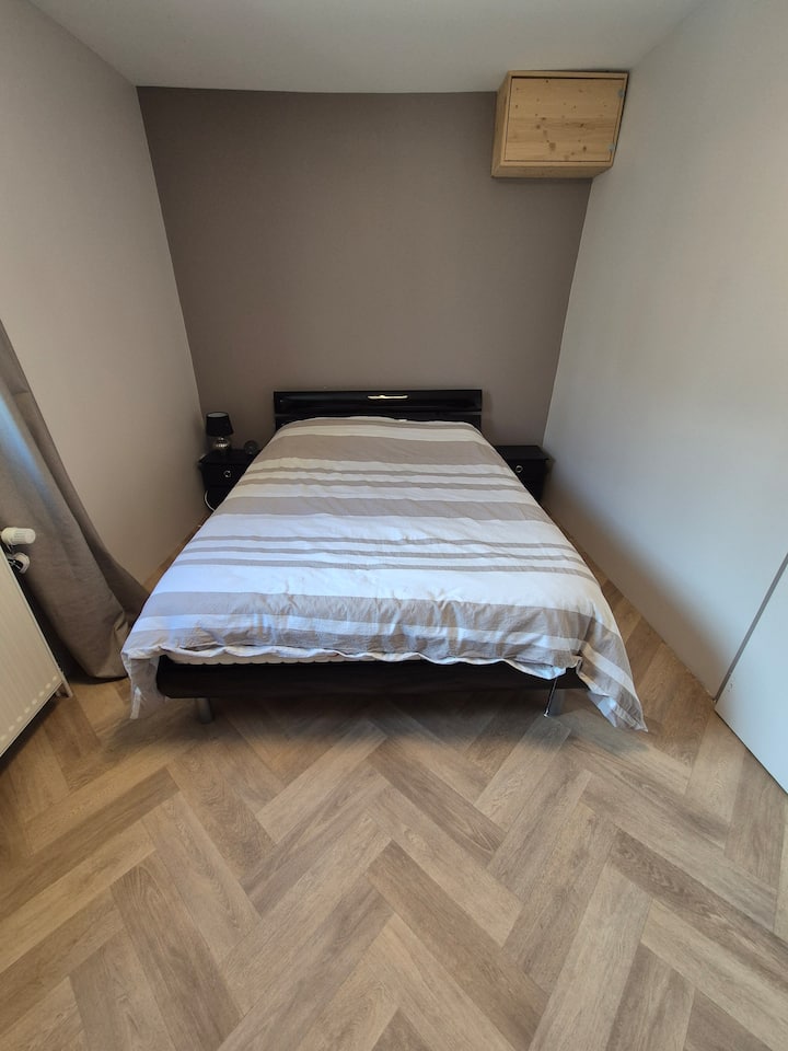 A la derecha de la cama, un enchufe con una lámpara de noche. 