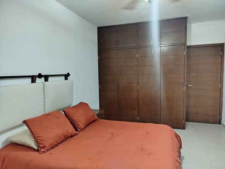 Chambre avec climatisation, placard, vue sur la cour intérieure et lit Queen size.