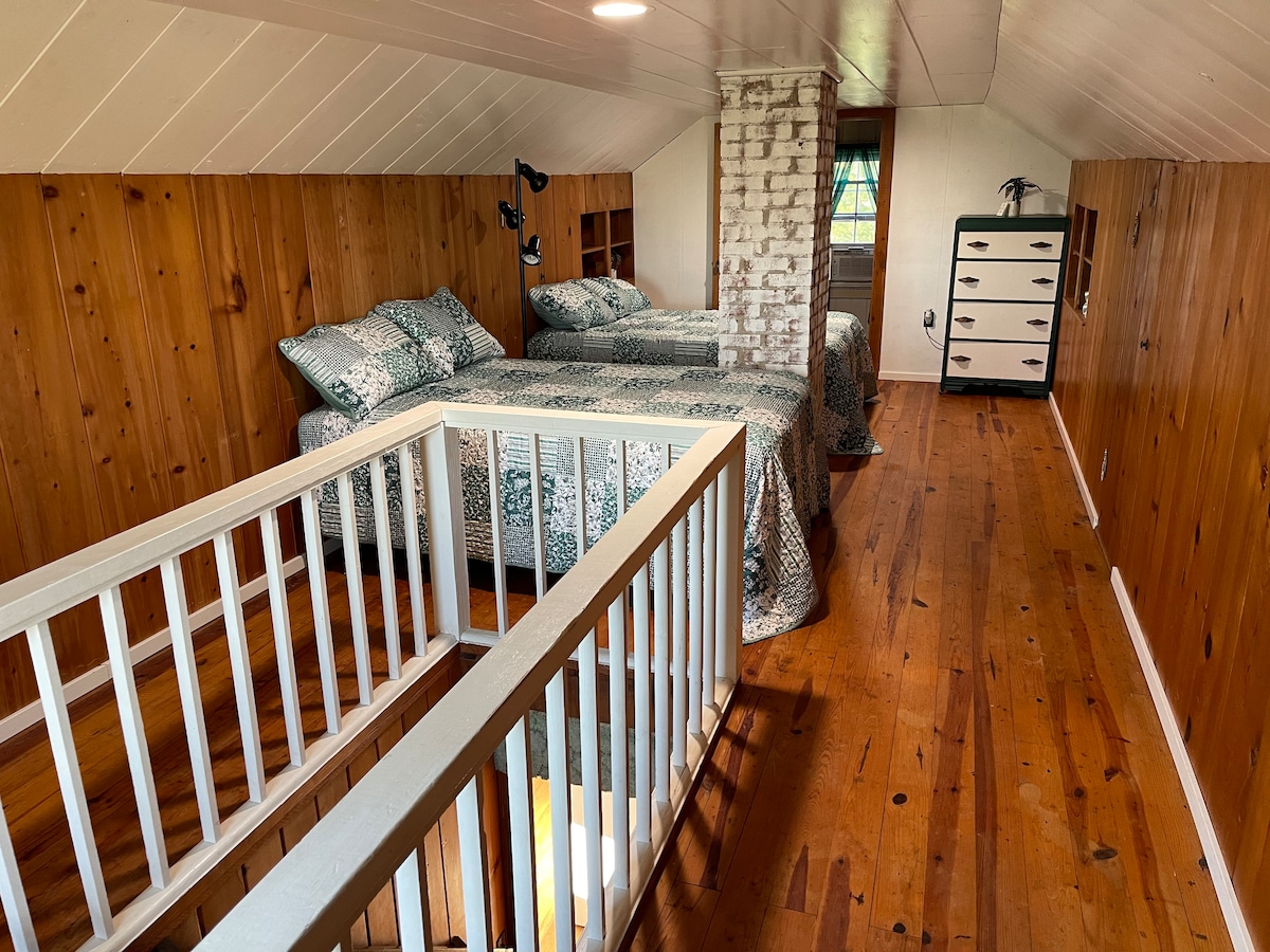 חדר השינה הזה נמצא בקומה השנייה של הבית במעלה גרם מדרגות.