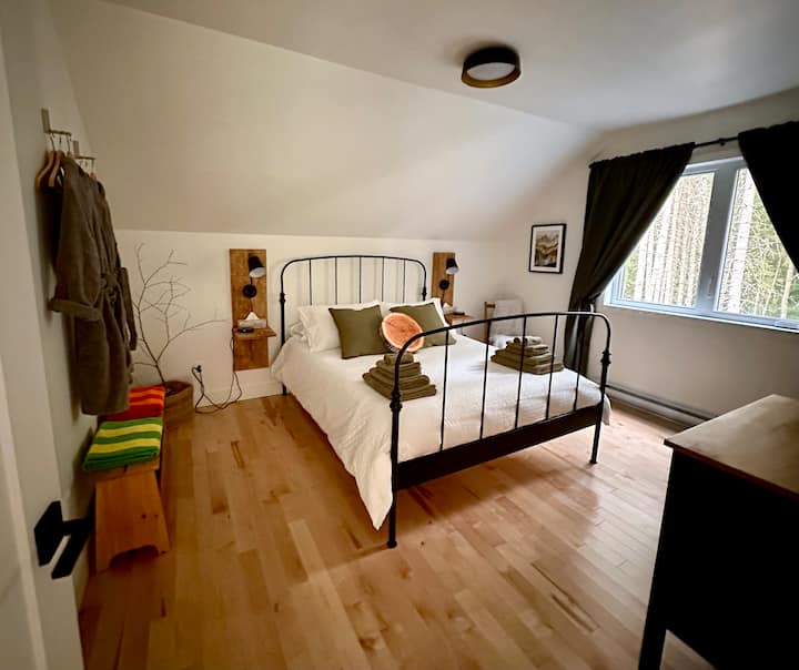 Large bedroom with queen-size bed, storage, and a small work area.
