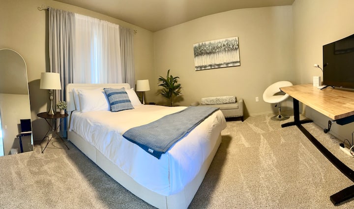 Comfortabel queensize bed, tv en werkplek. Badkamer 1 is toegankelijk via deze slaapkamer en heeft een inloopkast met planken, kleerhangers en een bagagerek. 