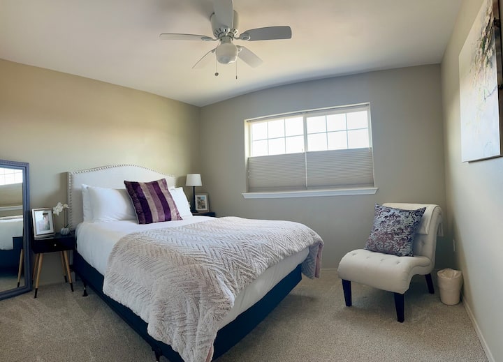 Comfortabel queensize bed met grote kast, opbergrekken en kleerhangers. Uitzicht op de bergen. Blauwe tandluidspreker in kast.