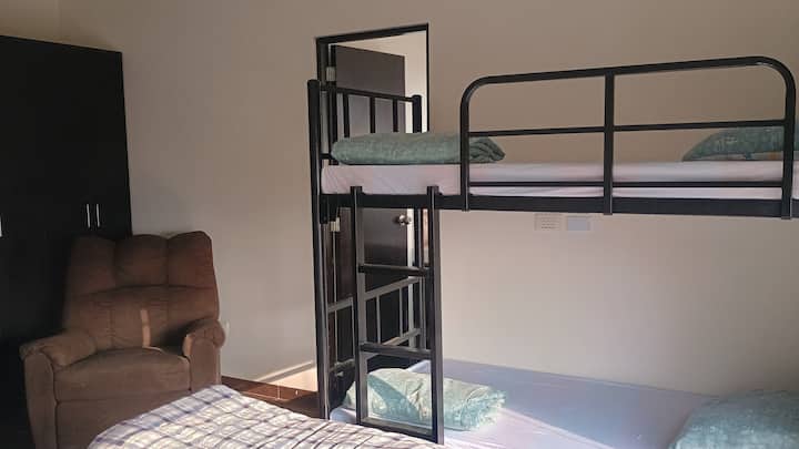 Dormitorio para 4 huespedes. Con baño privado y terraza. Cuenta con un cama de  2 plz más un camarote de 1 plz. tiene clóset, sillón reclinable, ropa de cama, almohada con funda y frazada).