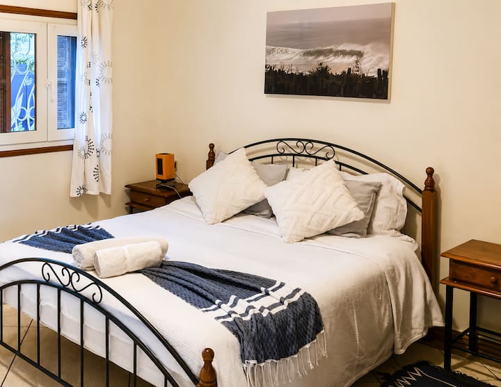 Quarto elegante com cabeceira de ferro forjado — toques marinhos e conforto refinado