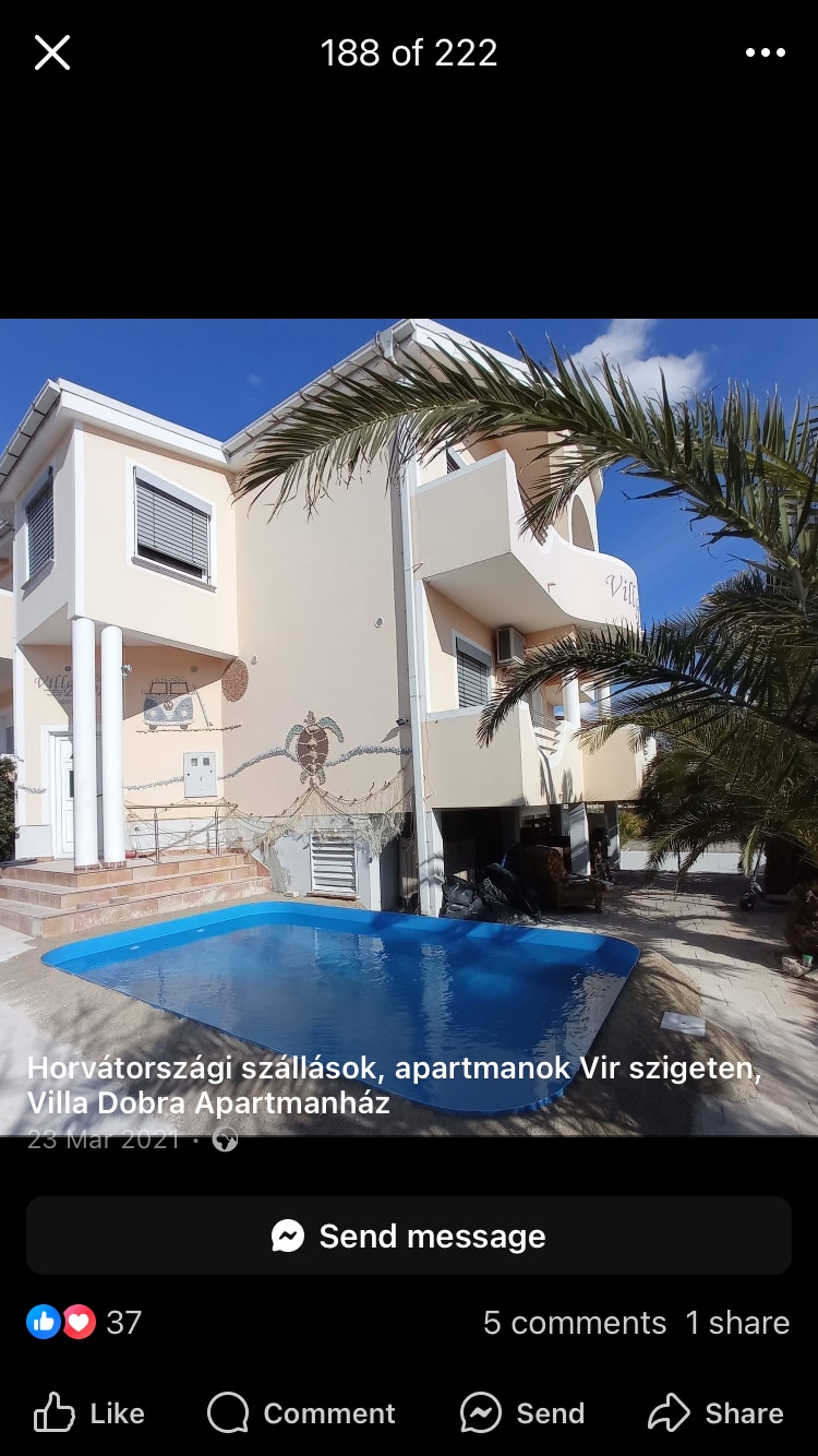 A two-story villa with light-colored exterior walls is showcased beside a small, inviting pool. Lush palm trees frame the space. The pool area is designed for relaxation, with tiles leading up to the entrance of the villa.
