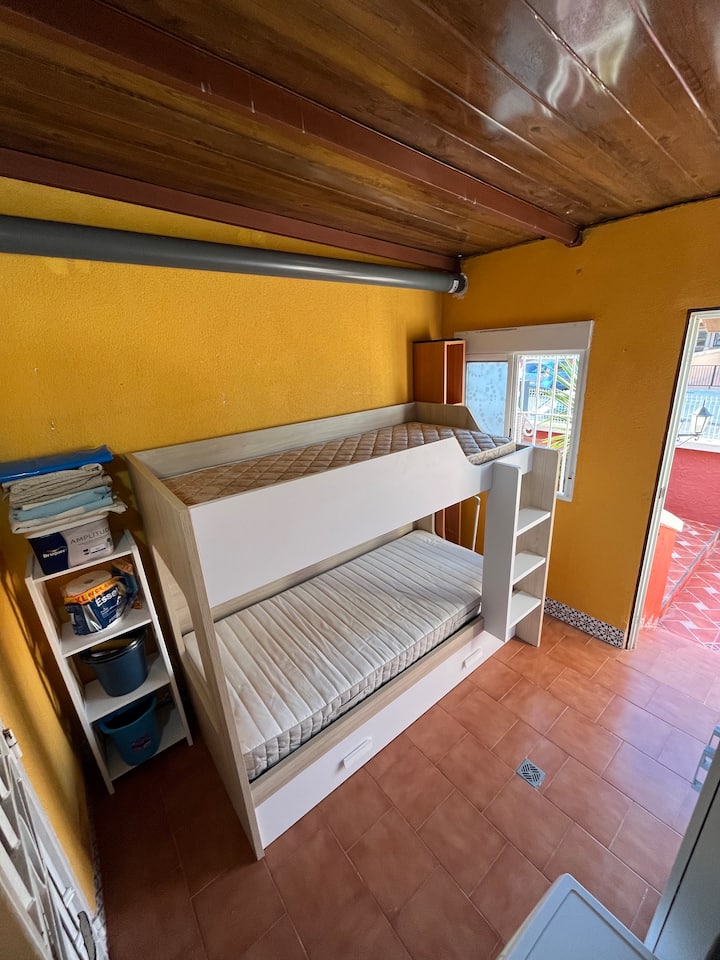 Slaapkamer/bijkeuken, voorzien van het stapelbed, maar ook wasmachine, strijkplank en dergelijke.