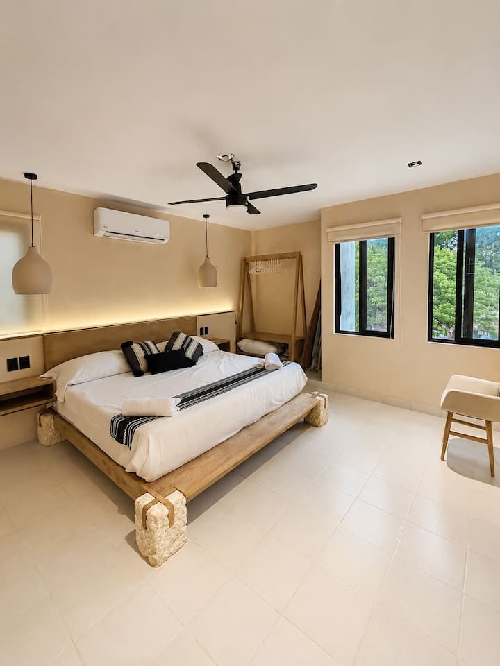 Master bedroom with solid wood bed and rustic stone base. A wabi-sabi design that evokes stability, warmth, and the deepest rest.