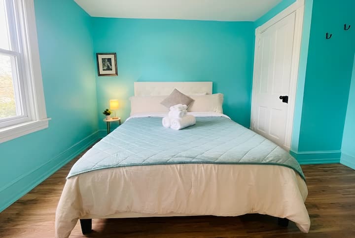 A colorful and relaxing retreat. This sunny bedroom features blackout shades and a pop of color to brighten your stay