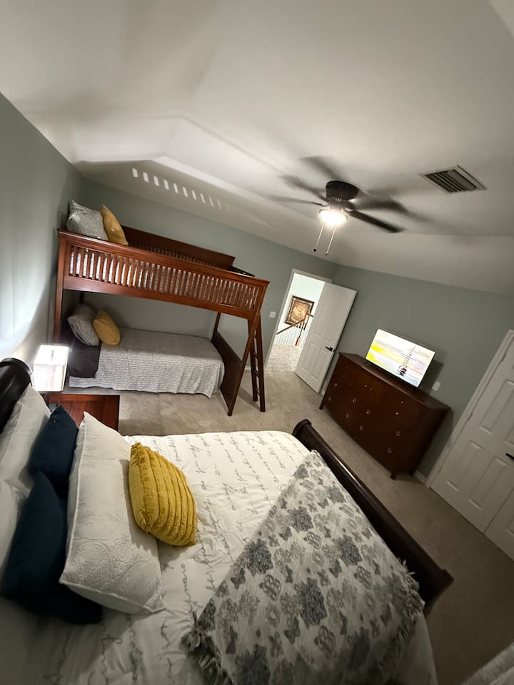 Este dormitorio tiene una cama de tamaño completo, una litera superior de tamaño completo y una cama individual debajo. Equipado con ventilador de techo, armario grande, portaequipajes, televisión inteligente, cargador portátil para cargar el teléfono, lámpara y almohadas y mantas adicionales. Ubicado en la parte superior de las escaleras.