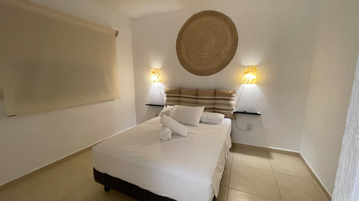 غرفة رئيسية مريحة بسرير مزدوج وإضاءة دافئة وديكور رائع. مساحة مثالية للراحة والاسترخاء مع ستائر سوداء.  