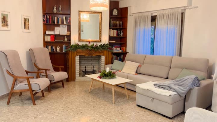A spacious dining room with a double sofa bed and a fireplace that has a bookcase on the sides and invites you to relax and enjoy. Books are available to guests in multiple languages and for adults, youth, and children.