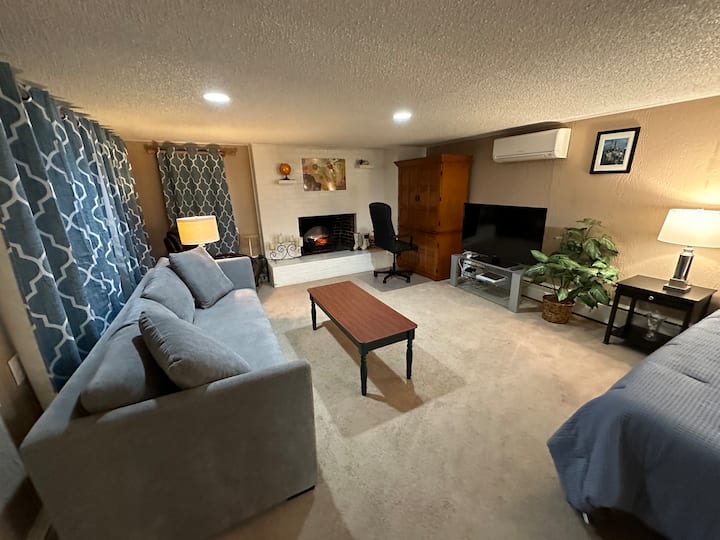 ספה נוחה הופכת למיטה זוגית. כיסא נדנדה מסתובב בפינה.