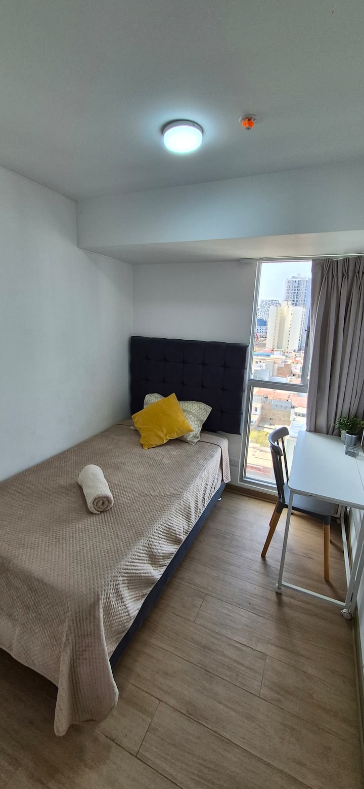 Habitación 2: Cama 1.5 plazas con escritorio. Vista hacia la calle.