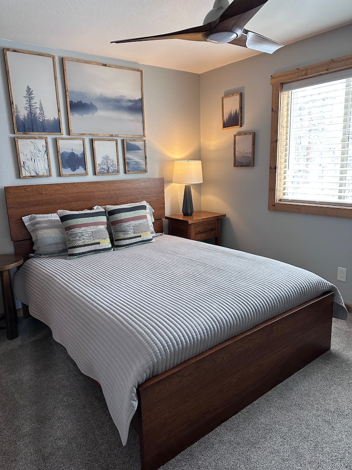 ห้องนอนแขกที่สว่างและน่าอยู่พร้อมเตียงควีนไซส์ มองเห็นวิวป่า