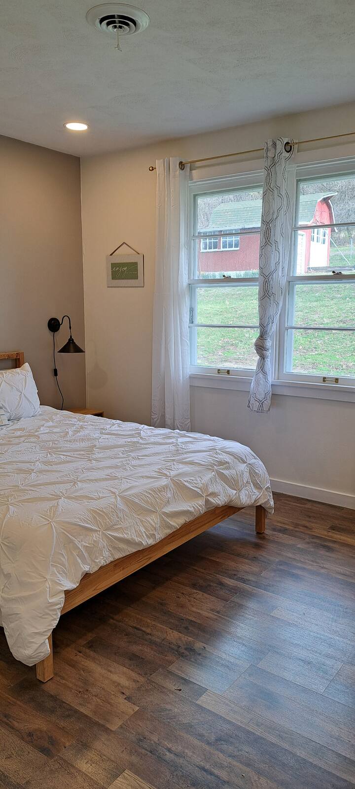 Chumba hiki cha kulala chenye utulivu kinatoa mapumziko yenye starehe yenye mtindo mdogo, kitanda chenye umbo la mbao na madirisha makubwa yanayoangalia sehemu ya nje yenye ladha nzuri inayofaa kwa ajili ya kupumzika na kupumzika.

