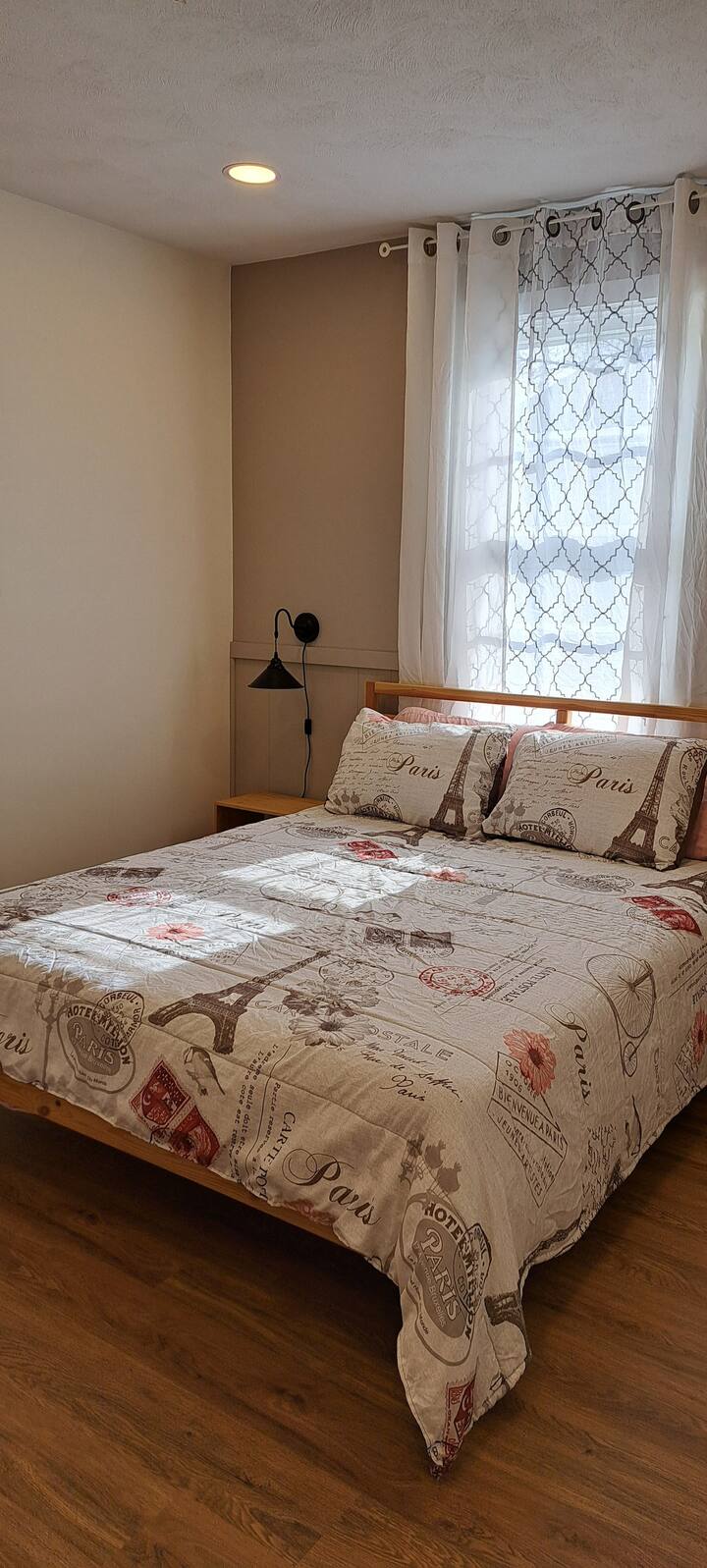Chumba hiki cha kulala chenye utulivu kina kitanda cha ukubwa kamili kilicho na matandiko yenye mandhari ya Paris, kona yenye starehe na dirisha kubwa ambalo linakaribisha katika mwangaza laini wa asili kwa usiku wa kupumzika.

