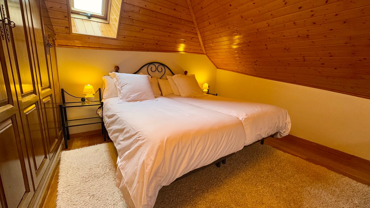 استرح على هذه الأسرة الفردية تحت سقف خشبي مريح ونافذة تطل على السماء  