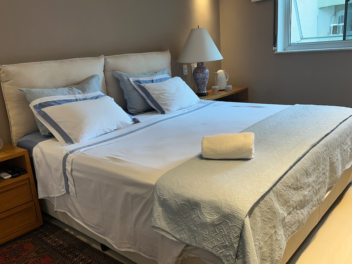 Kingsize bed, laken, sprei, lamp, nachtkastje, twee kussens, gordijn en twee kussens. 