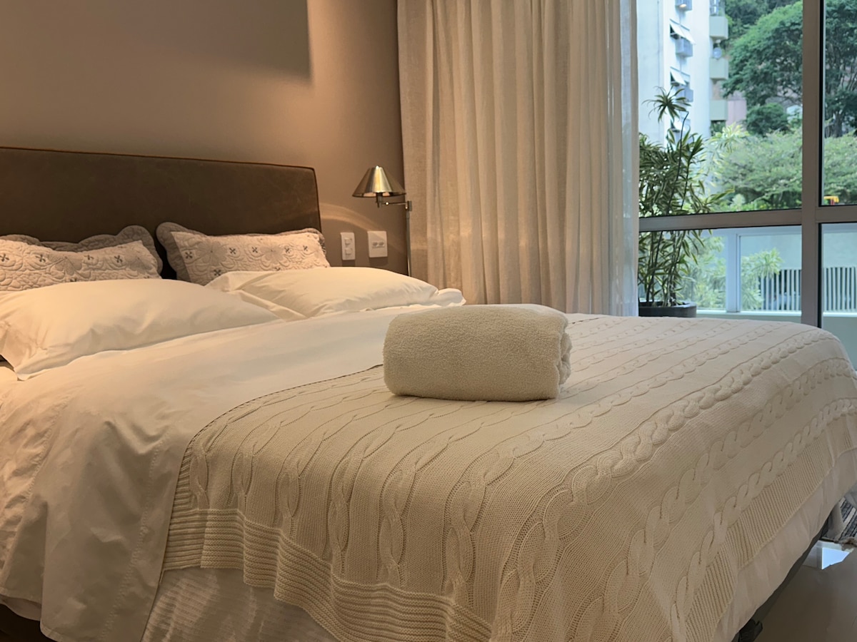 Queensize bed, 4 kussens, laken, deken, gordijn, verduistering en uitzicht op het groen.