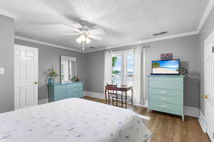 Queen bed upstairs with view of the water and designated workspace 