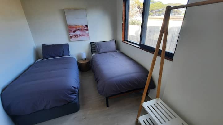 เตียงเดี่ยว 2 หลังและพื้นที่แขวน