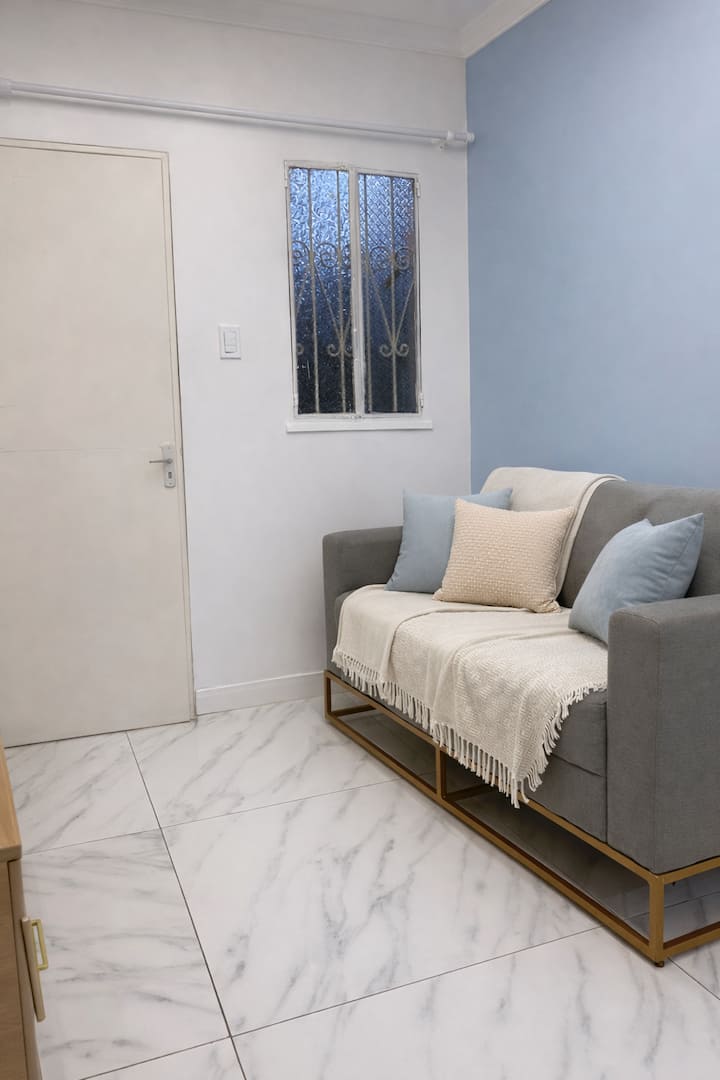 Salon avec un sofa confortable et une atmosphère compacte et chaleureuse.
