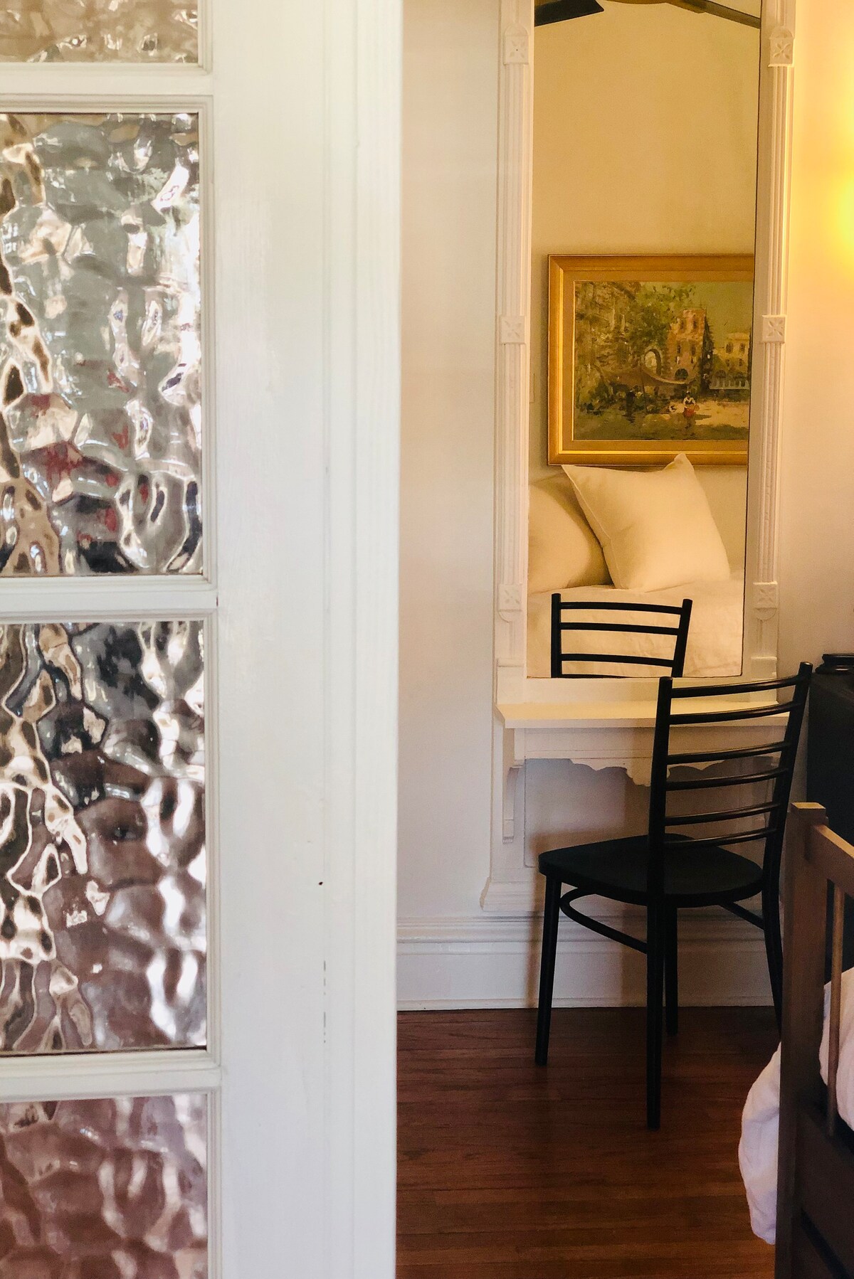 Enter through the original french doors to secondary bedroom. The antique pier mirror make a charming dressing station.