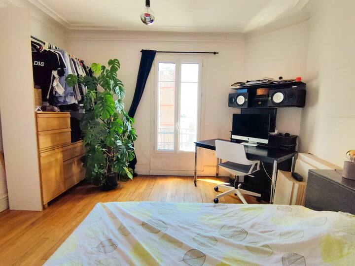 Entrée de la chambre. Vue sur les toits de Paris par cette fenêtre sans vis-a-vis. Soleil direct durant toute l’après midi orientation sud ouest. Donne sur cour donc très calme. Dressing, cintres, bureau, lit queen size. Grand poster psyche