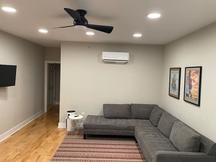 LA sala DE estar: este acogedor espacio cuenta con una sección cómoda, un ventilador de techo y un televisor montado en la pared. Perfecto para relajarse después de un día explorando la zona.