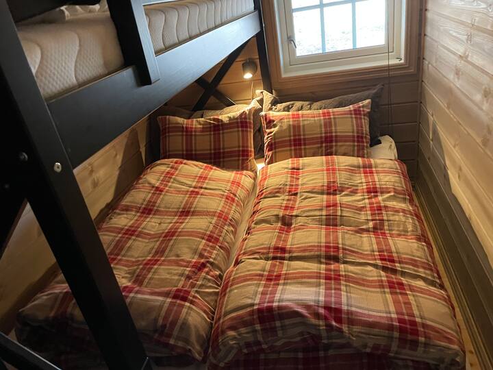 Esta habitación tiene un tamaño de litera maciza. colchones de 75 cm de ancho. Una litera superior individual y una cama extraíble en la litera inferior de 75 a 150 de ancho. Tiene capacidad para 3 personas aquí. Hay ropa de cama y toallas incluidas en el alquiler. Edredones con calidad hotelera.