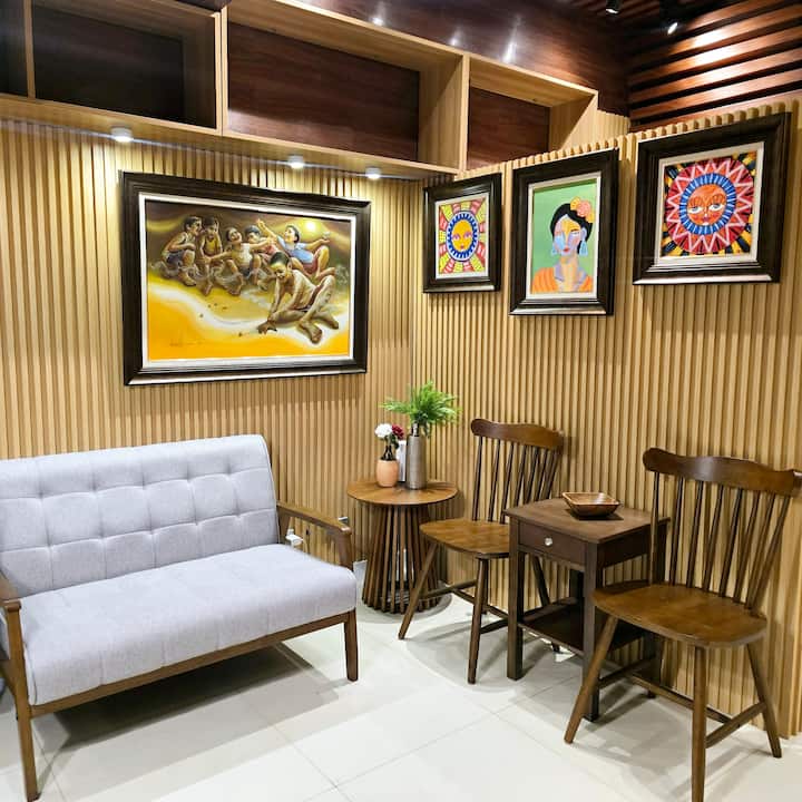 Entrez dans un salon débordant de couleur et de personnalité, où le flair artistique rencontre un confort confortable. Orné de peintures vibrantes qui enflamment votre imagination, cet espace vous invite à vous détendre et à vous imprégner de la créativité qui vous entoure.