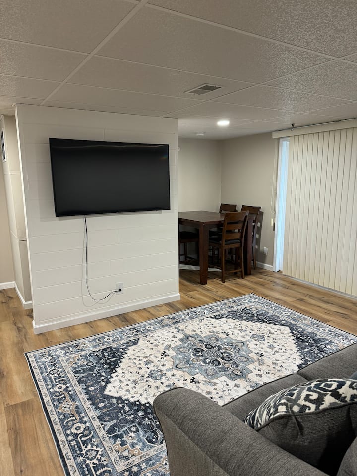 Sebule ya ghorofa ya chini inatoa mapumziko ya starehe yenye kitanda cha sofa cha ukubwa wa malkia, viti 4 vya meza na ufikiaji rahisi wa baraza. Ni mahali pazuri pa kupumzika na kutazama televisheni, iwe ni kupumzika baada ya siku moja ziwani au kufurahia usiku tulivu huko.