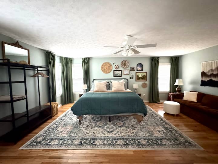 Масивната родителска спалня включва двойно легло king size, кът за сядане, работно място, телевизор и самостоятелна баня.