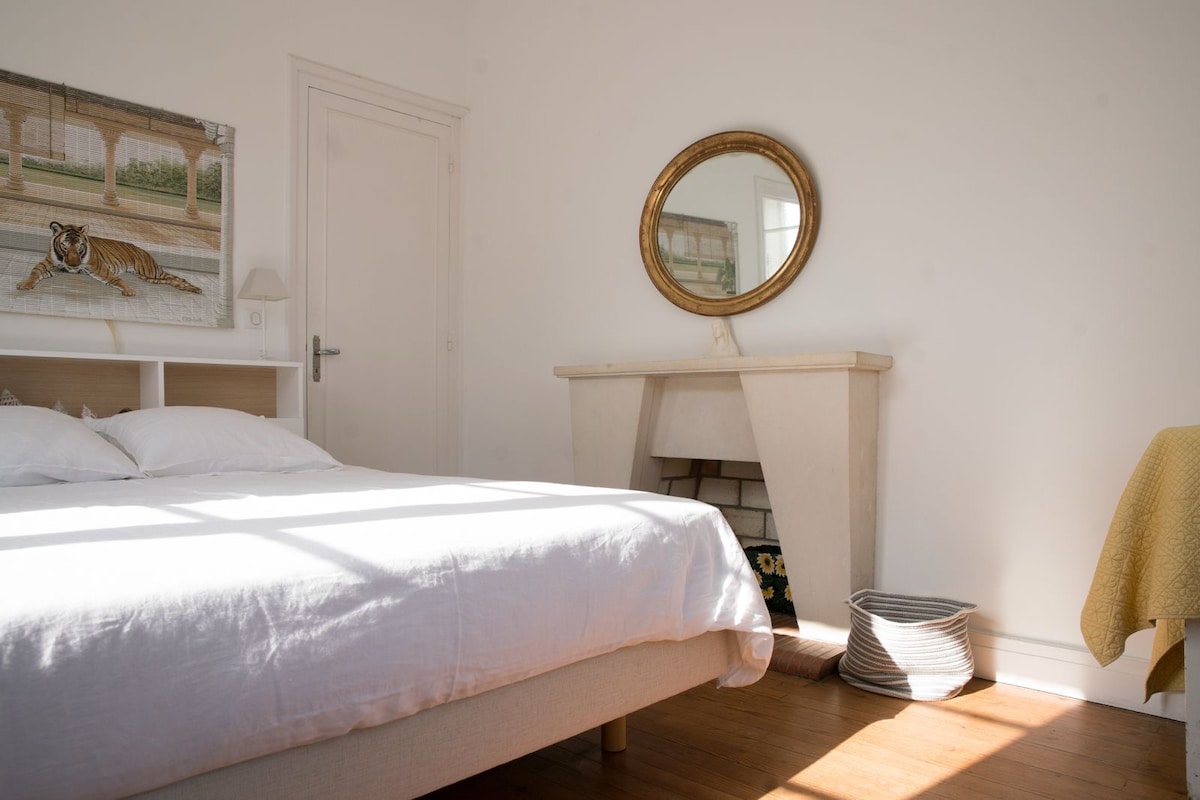 Спална соба на горниот кат со приватна бања со поглед кон предната градина. 