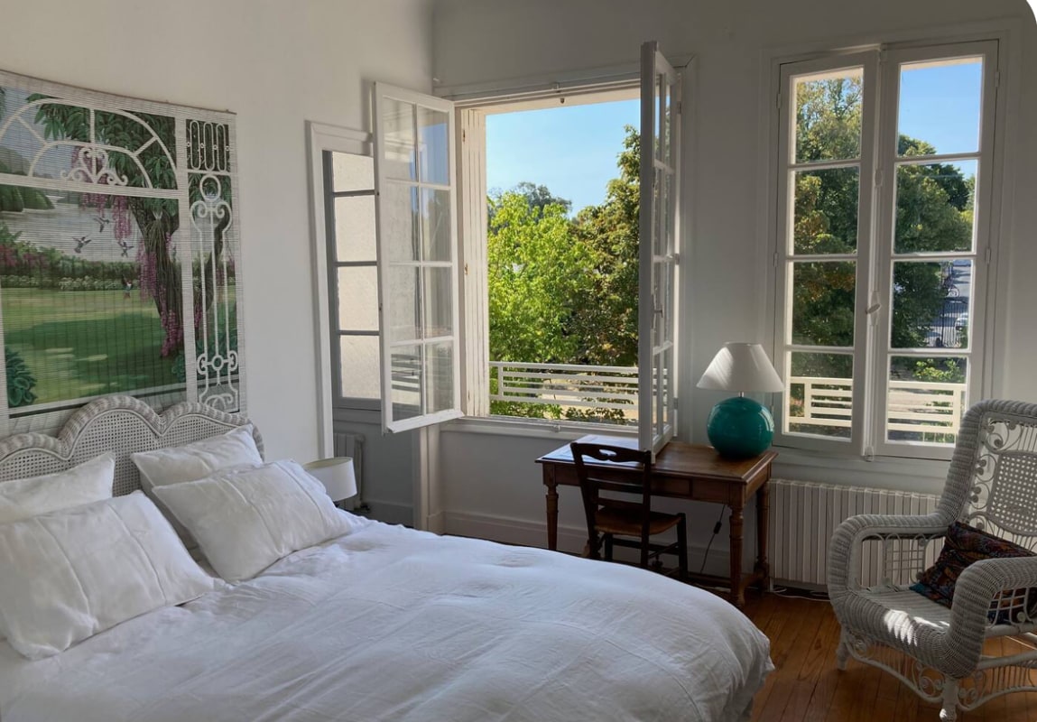 Спална соба на горниот кат со приватна бања со поглед кон предната градина. 