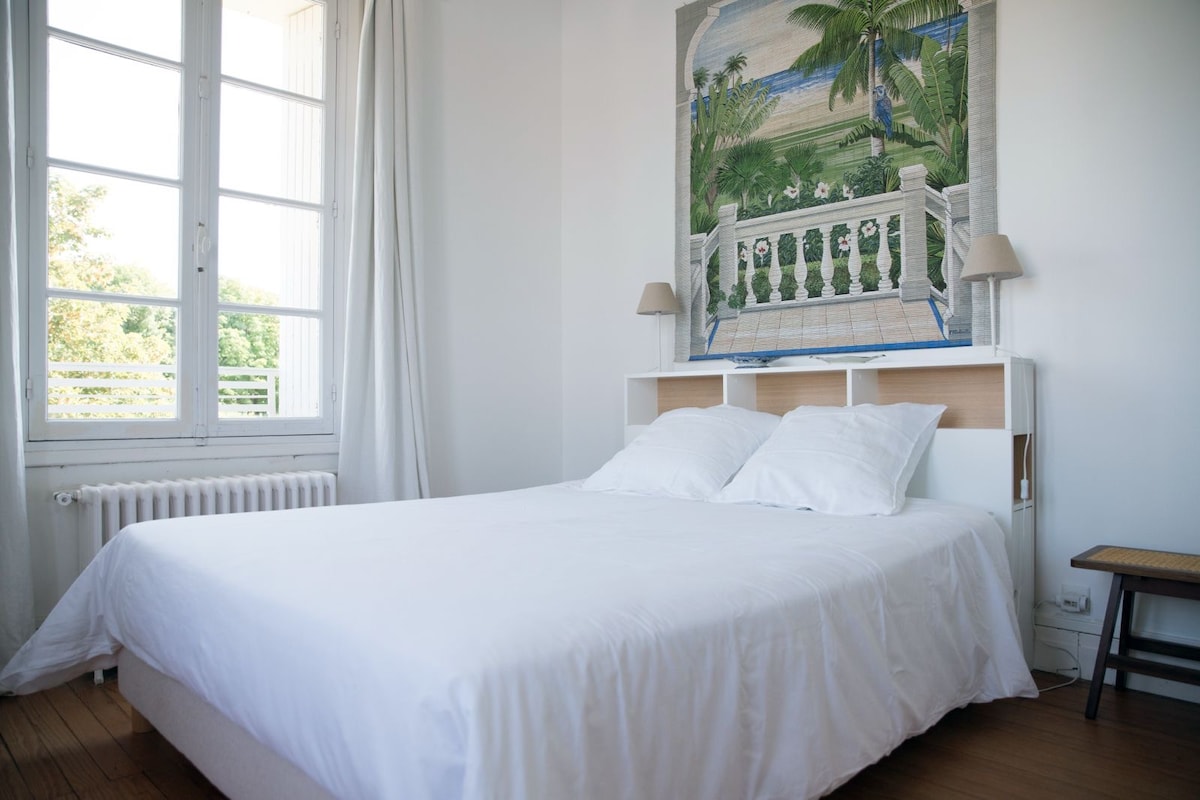 Спална соба на горниот кат со приватна бања со поглед кон предната градина. 