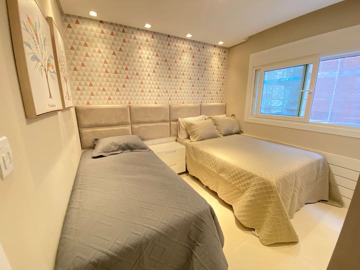 La sala social tiene una cama doble y una cama individual + auxiliar, aire acondicionado frío/calor, televisor inteligente, ventana con pantalla protectora y armario. 1763038531