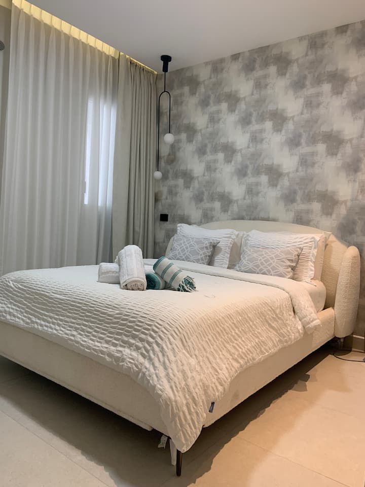 The second bedroom offers a cozy queen-size bed for a restful stay. Tasteful decor and soft lighting create a welcoming atmosphere for additional guests or family. Closet space available. Final touches coming soon!
