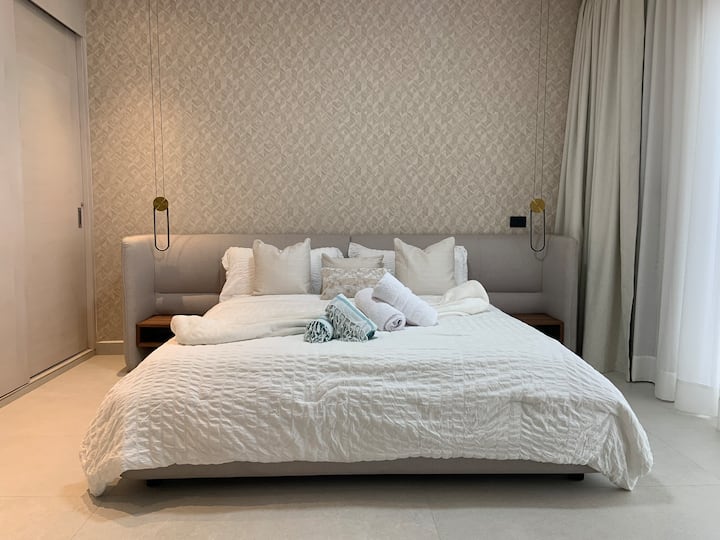 Another view of the master bedroom showcasing the spacious layout and ample closet space. Imagine unpacking and settling into your beachfront retreat. Comfortable king bed and serene ambiance.