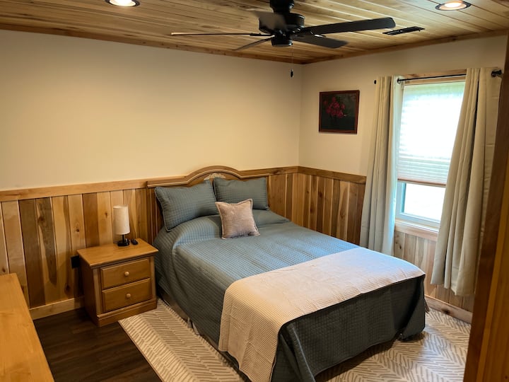 Dormitorio principal con cama tamaño queen. Ventilador grande de techo y de pared.