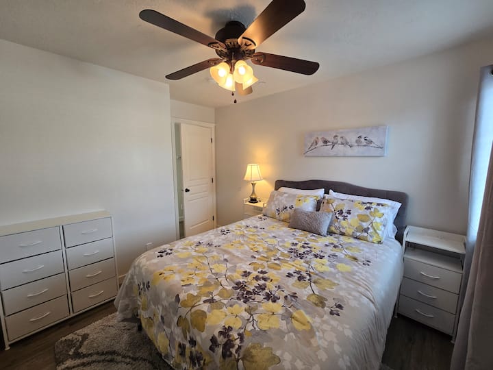 Cama tamaño queen con mesitas de noche que proporcionan energía para cargar dispositivos electrónicos. 