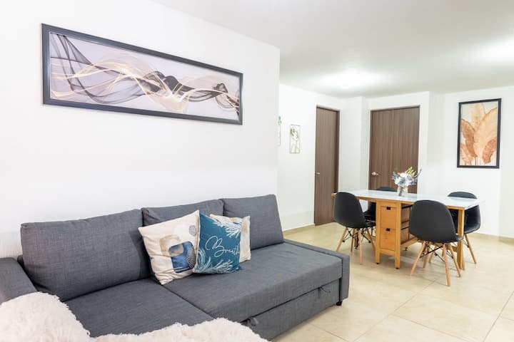 ห้องนั่งเล่นที่อบอุ่นพร้อมเตียงโซฟา เหมาะสำหรับการเพลิดเพลินหรือพักผ่อนหน้าทีวีขนาด 65" พร้อมมัลติมีเดีย