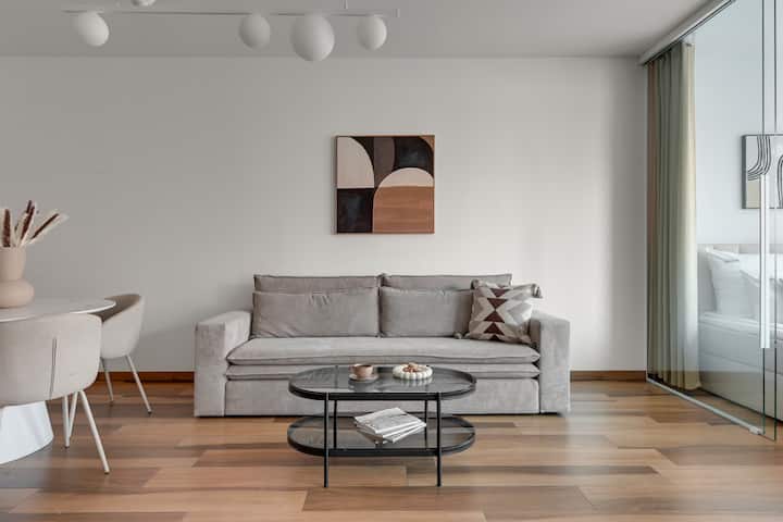 Най-голямото предимство на всекидневната са панорамните прозорци с изглед към река Мотлава и историческите сгради на Стария град. Удобен разтегателен диван, голям телевизор и елегантна маса за хранене са благоприятни за прекарване на време заедно.