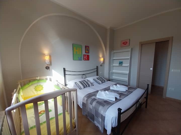Habitación doble con cama “queen size” (160 × 190) y cuna para niños.
