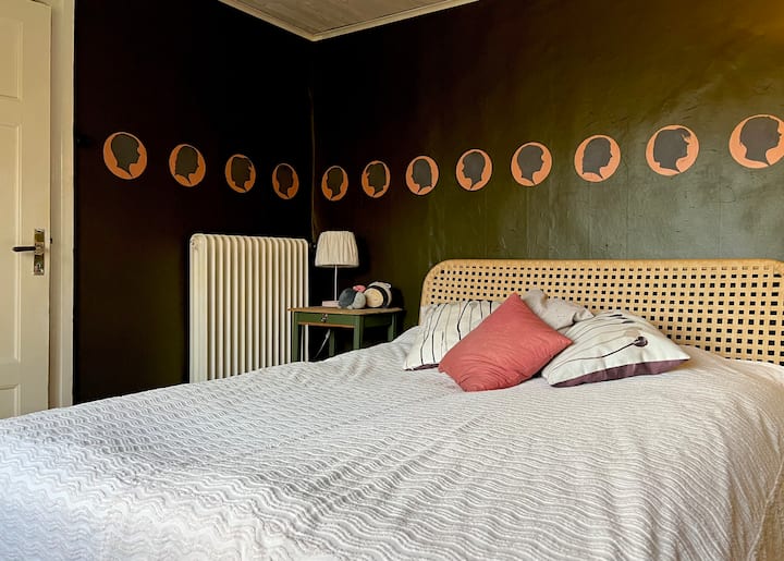 غرفة نوم في الطابق الأرضي مع سرير بحجم كوين (أبعاد 180 × 200 سم) وسرير بطابقين.